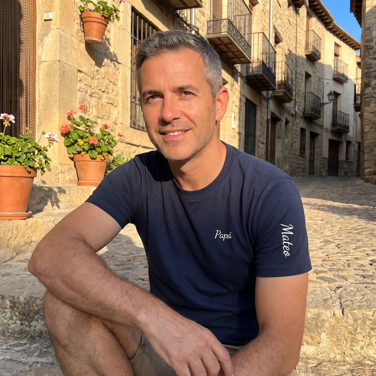 Hombre con la camiseta azul marino «Papá» en el pecho y «Mateo» a mano en la manga