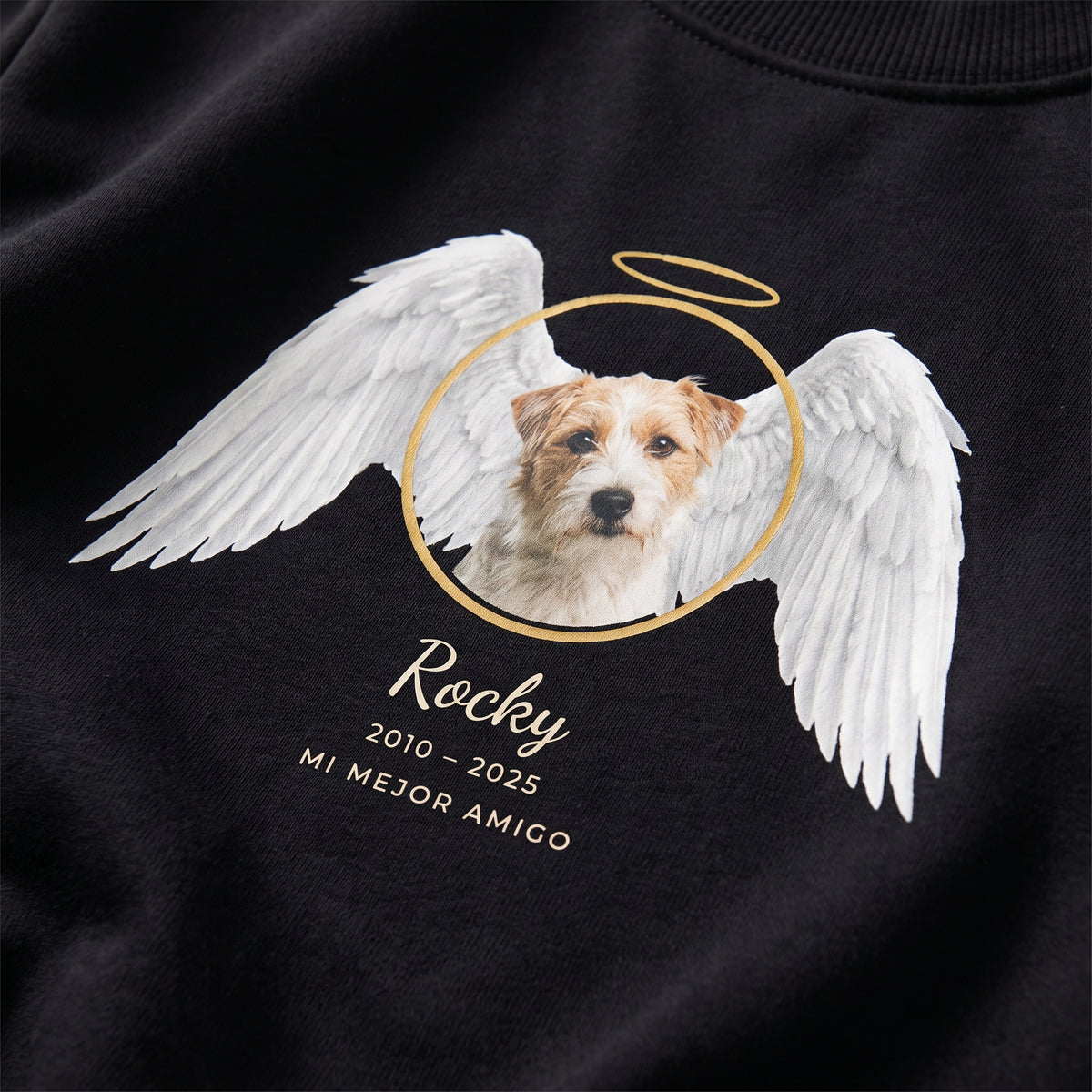 Detalle del estampado DTF en una sudadera negra: la foto de un perro terrier entre alas de ángel blancas con aureola dorada, Rocky, 2010 – 2025 y «Mi mejor amigo»