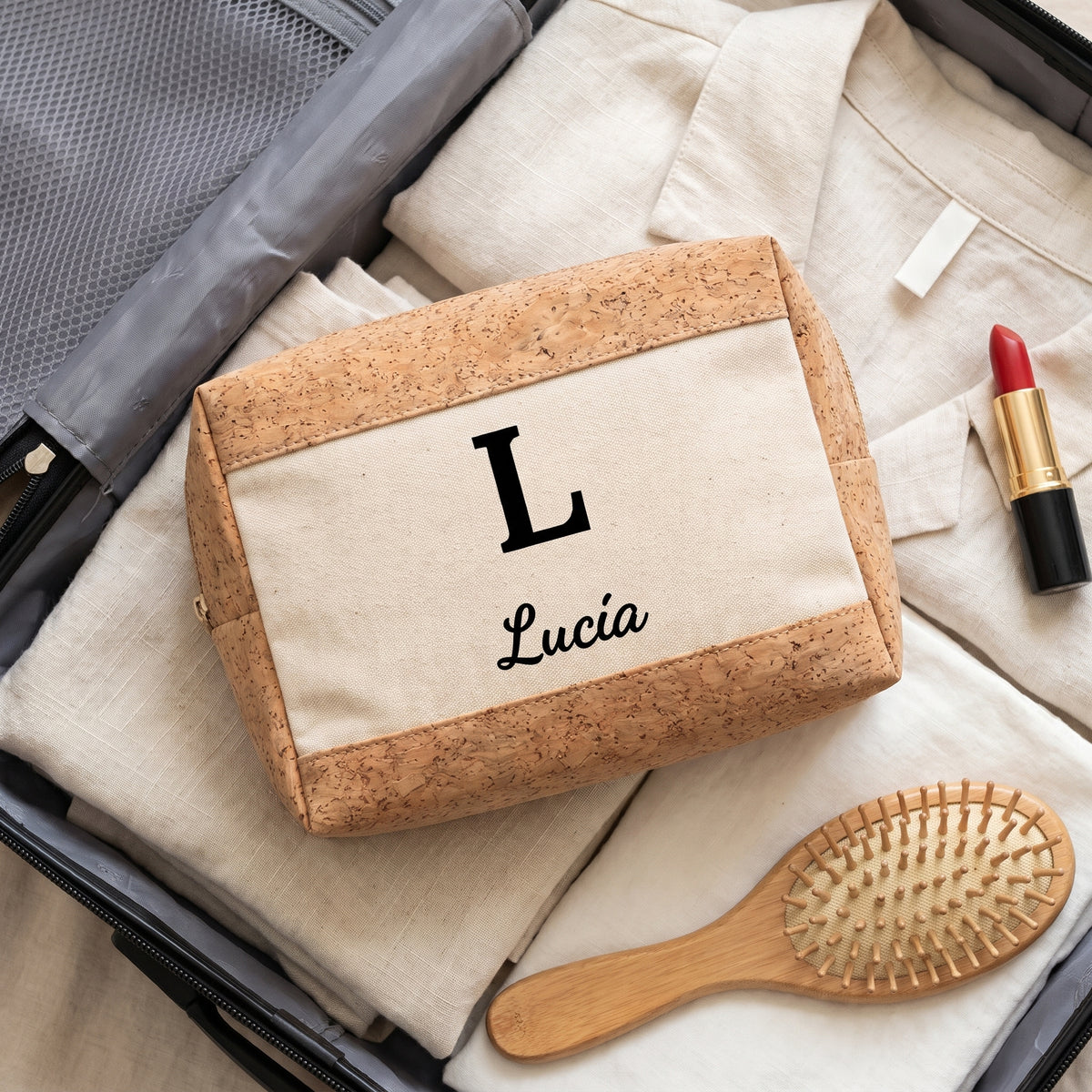 Neceser personalizado con inicial y nombre en una maleta de viaje