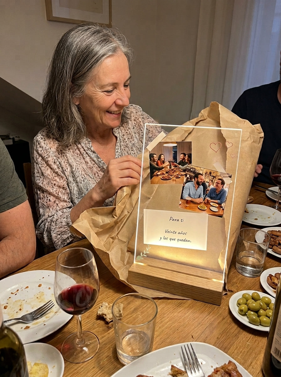 Abriendo el regalo de la placa de metacrilato personalizada con fotos y una nota en una comida familiar