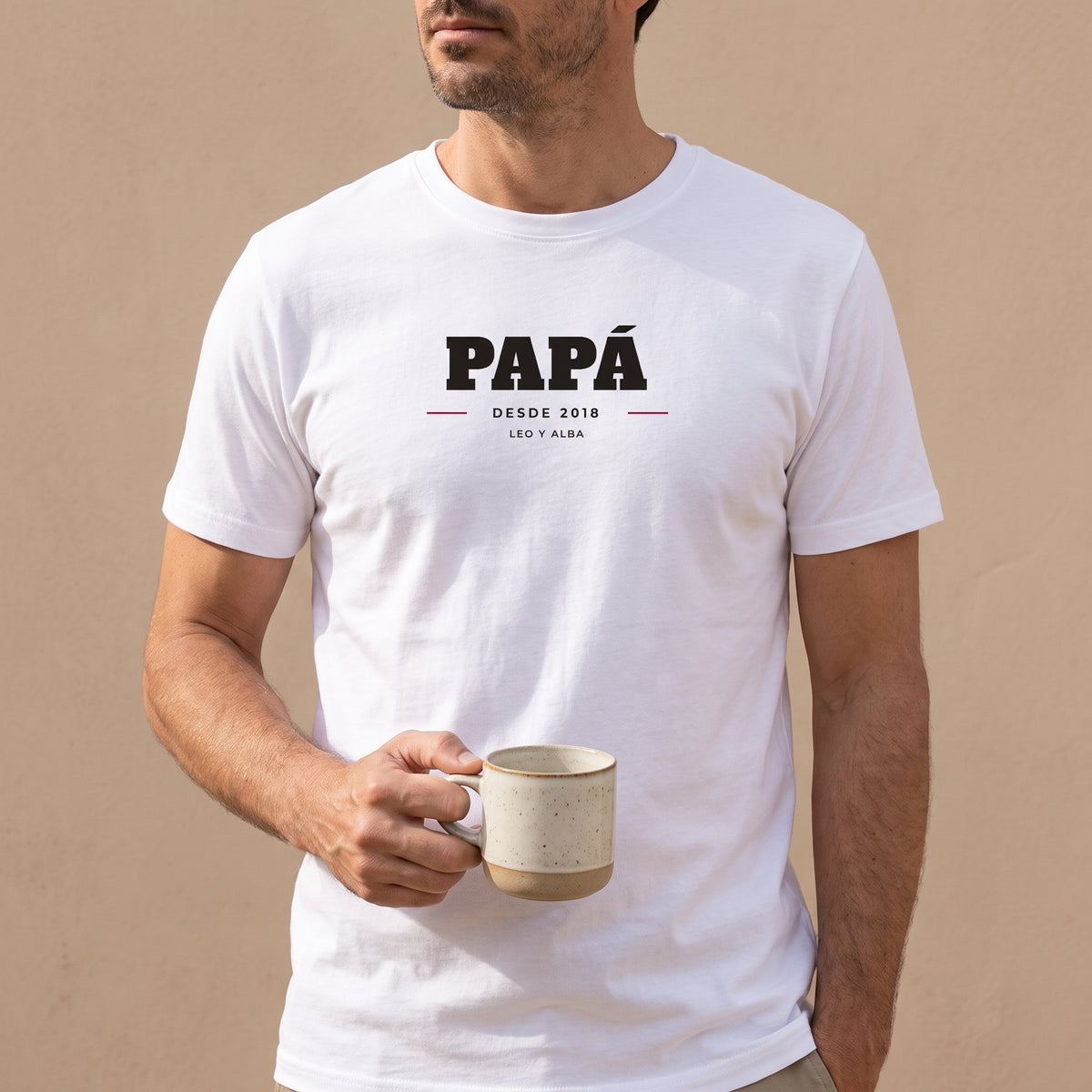 Hombre con la camiseta blanca personalizada con PAPÁ, DESDE 2018 y los nombres de sus hijos, Leo y Alba, estampado en el pecho