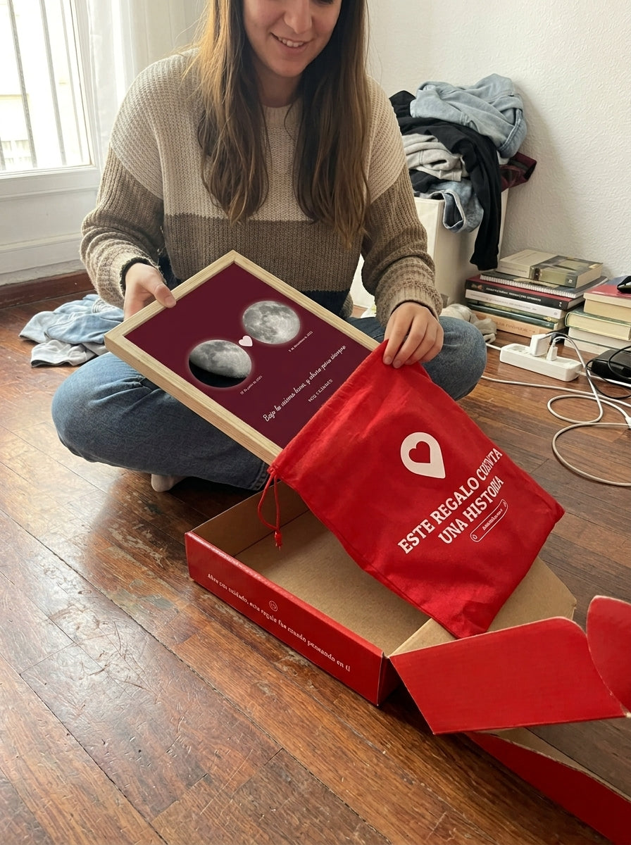 Sacando el cuadro fase lunar personalizado de pedida de mano de la bolsa de regalo, con la caja abierta al lado