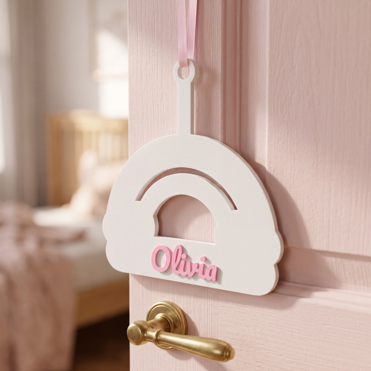 Placa de puerta arco iris con el nombre Olivia en una puerta rosa
