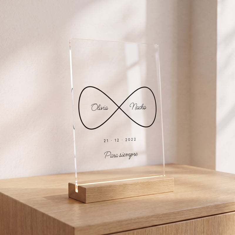 Placa de metacrilato personalizada infinito con nombres sobre un aparador de roble en una habitación luminosa, con su base de madera con luz