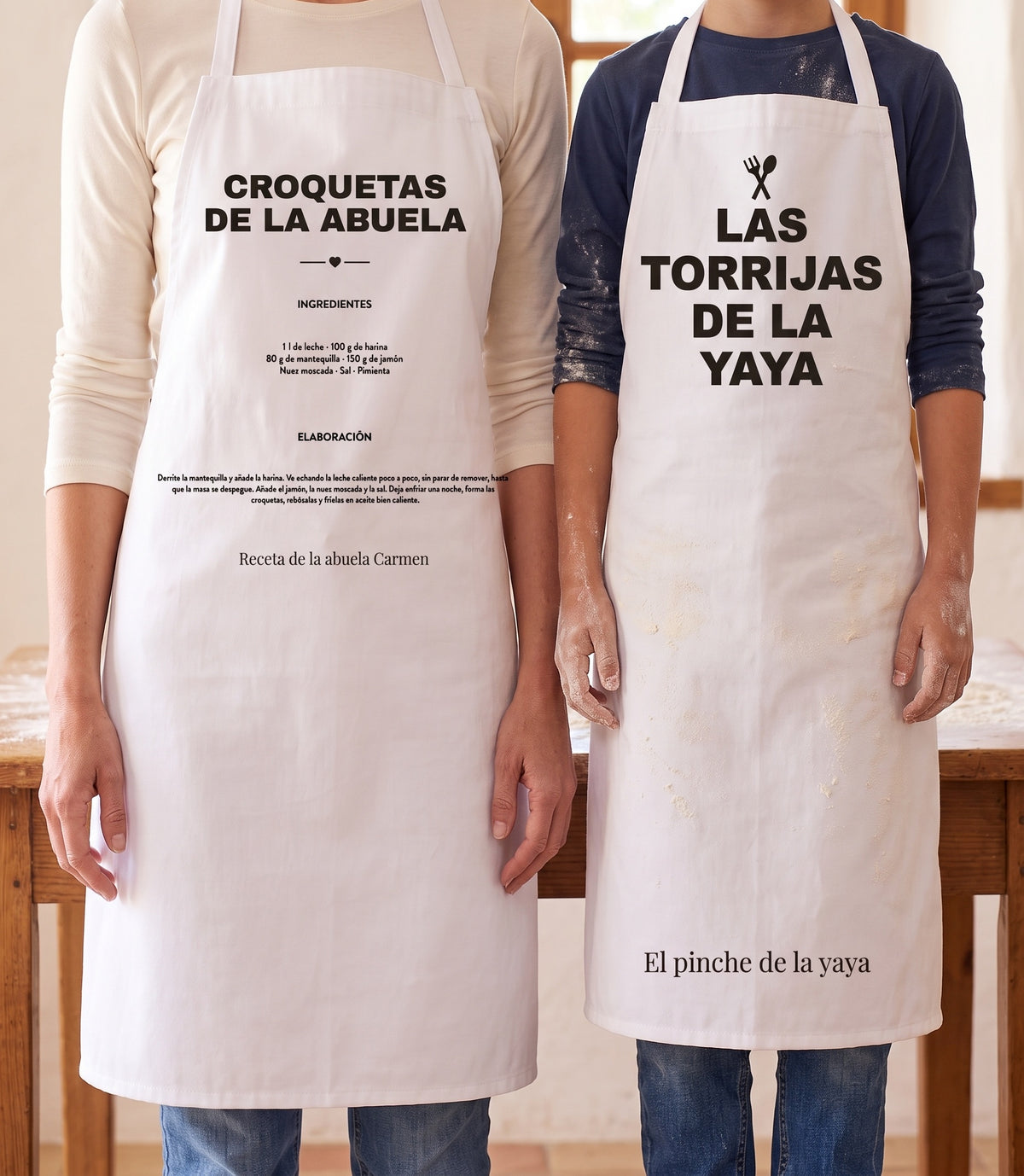 Delantal de adulto con la receta de las croquetas de la abuela y delantal de niño con «Las torrijas de la yaya», puestos los dos en la cocina