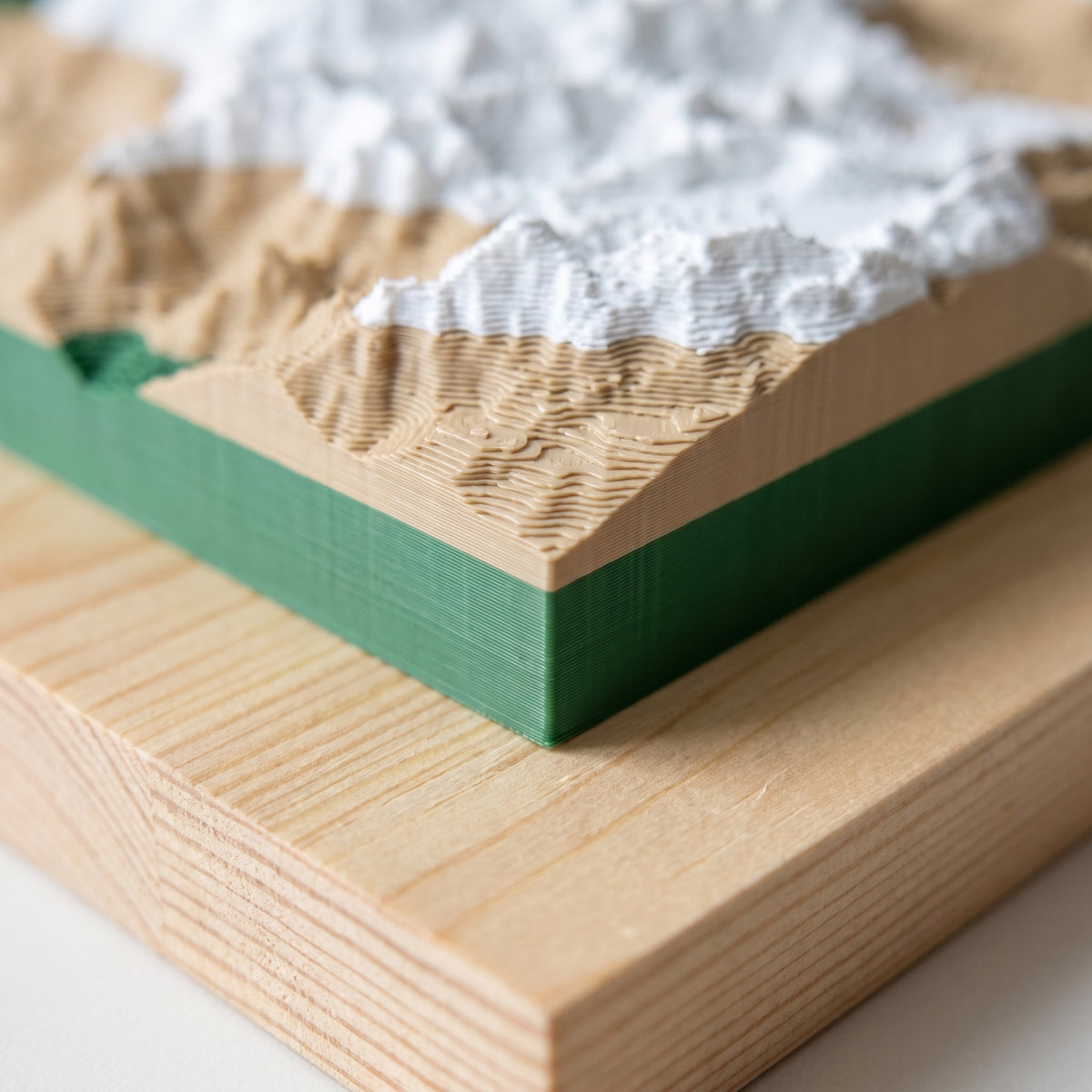 Primer plano de la esquina de un mapa 3D en relieve: las capas finas de la impresión y el canto de la tabla de pino