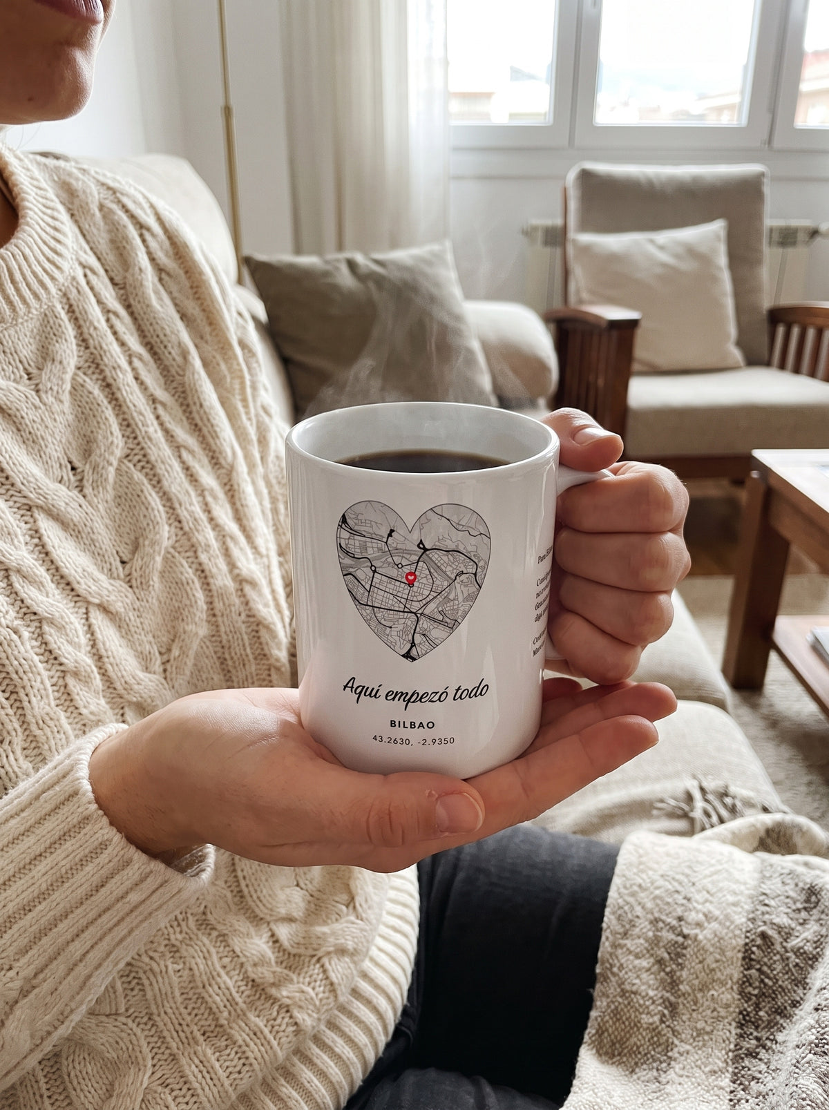 Taza ciudad con el mapa de Bilbao en corazón, con café entre las manos