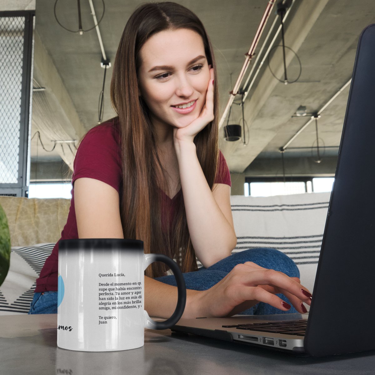 Mujer trabajando en el portátil junto a su taza mágica personalizada con una dedicatoria