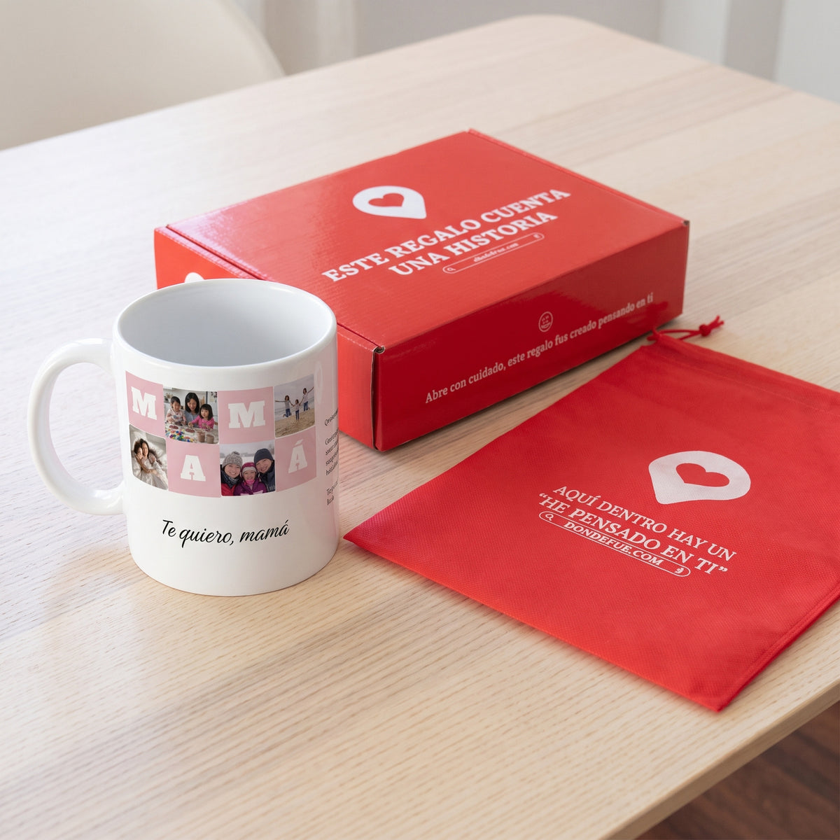Taza MAMÁ con 4 fotos (Te quiero, mamá): junto a la caja roja y la bolsa de tela roja en que se envía
