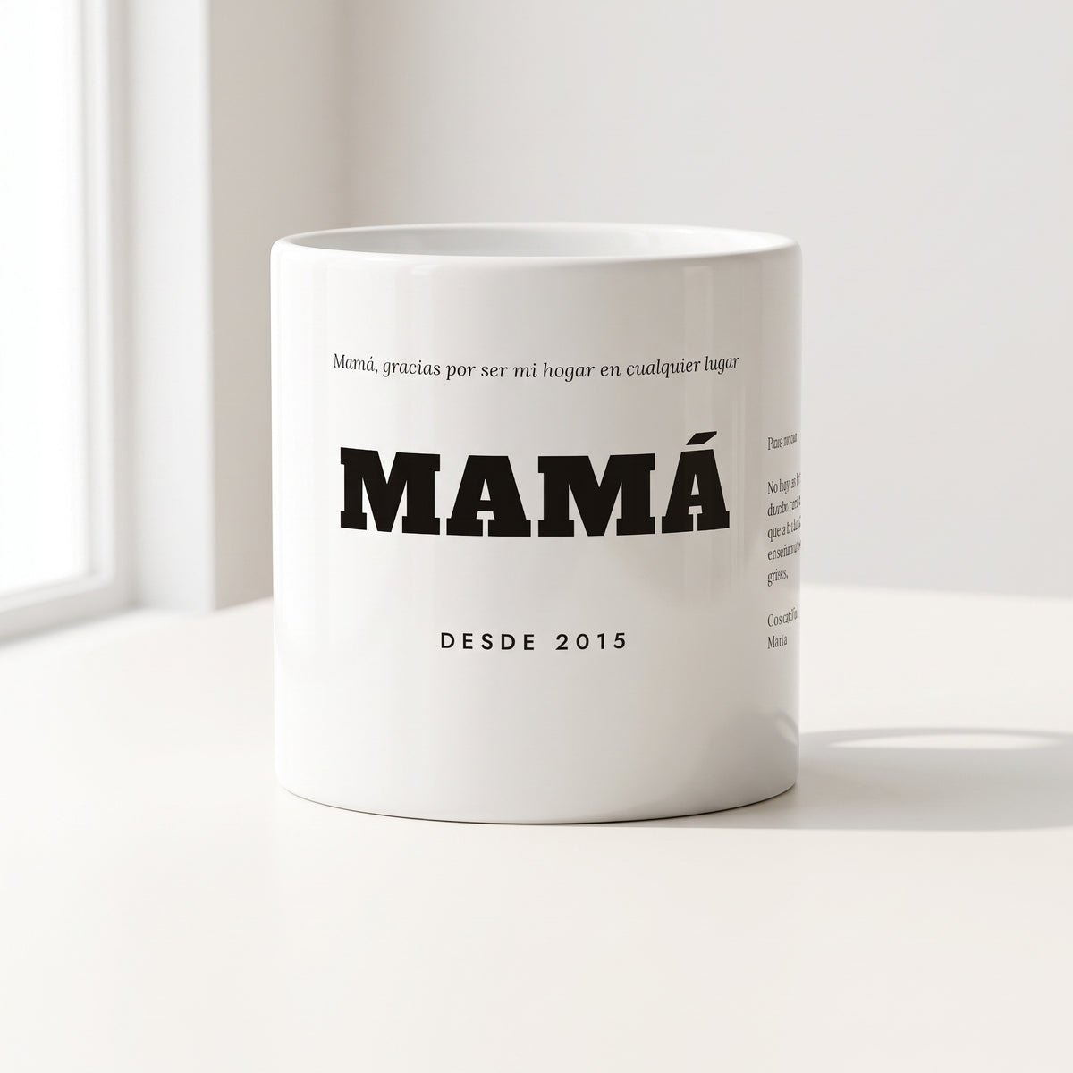 Taza MAMÁ con dedicatoria personalizada (Mamá, gracias por ser mi hogar en cualquier lugar · MAMÁ · DESDE 2015), con una carta en el costado