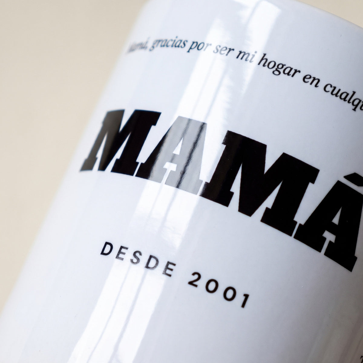 Taza MAMÁ con dedicatoria (Mamá, gracias por ser mi hogar en cualquier lugar · MAMÁ · DESDE 2001): detalle de la impresión sobre la cerámica