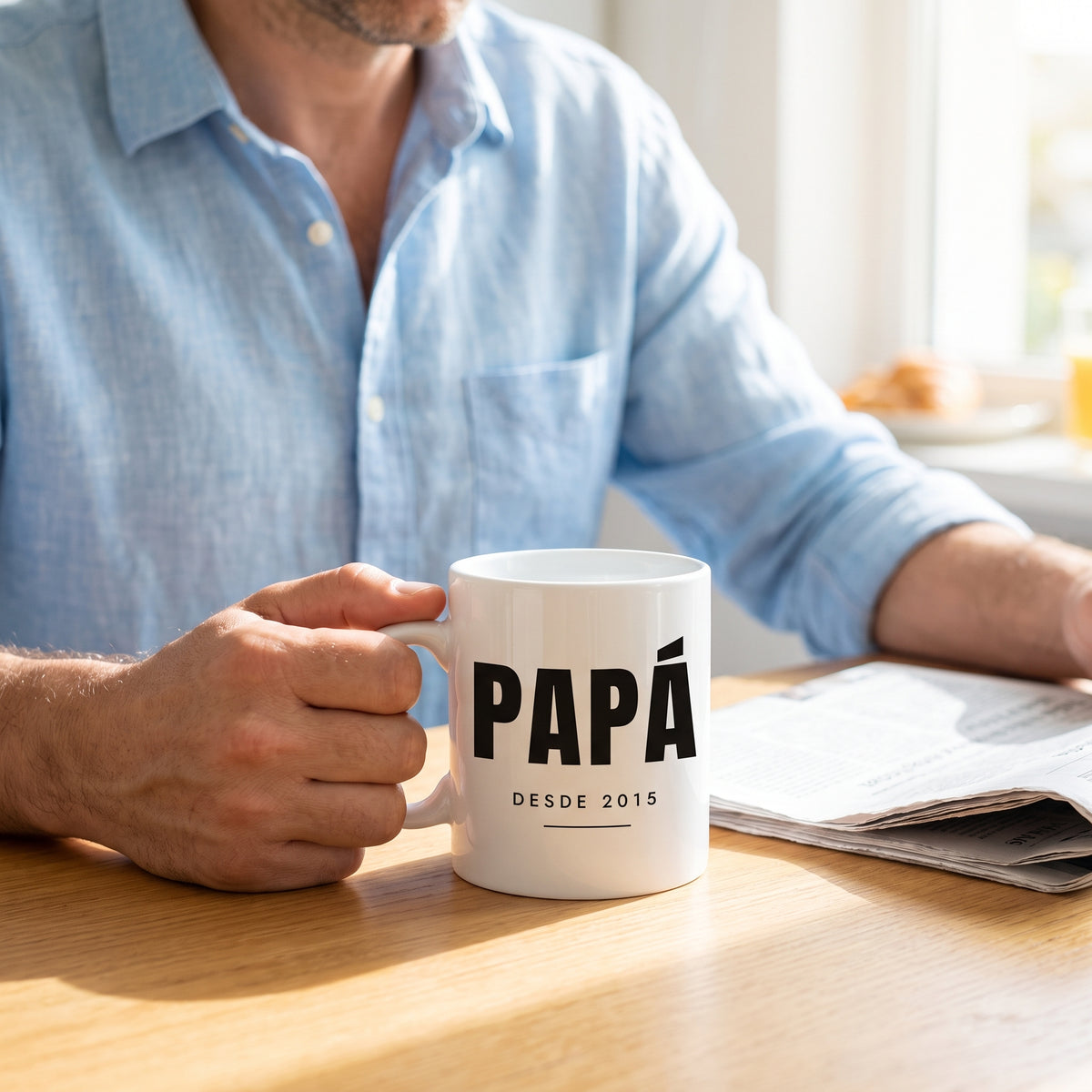 Manos sujetando la taza personalizada para papá con el año en grande