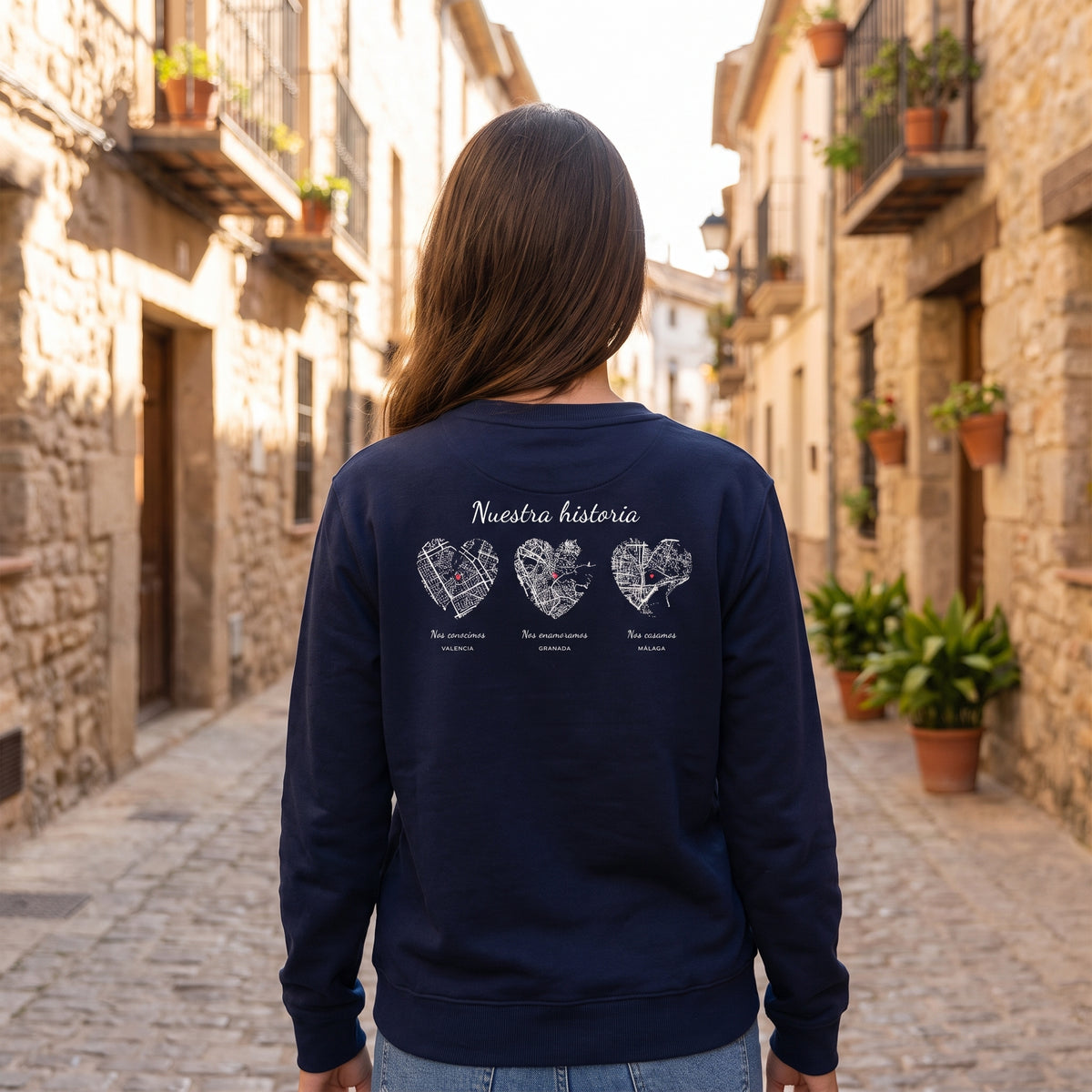 Mujer de espaldas con la sudadera azul marino personalizada con tres mapas en corazón: Valencia, Granada y Málaga estampado en la espalda