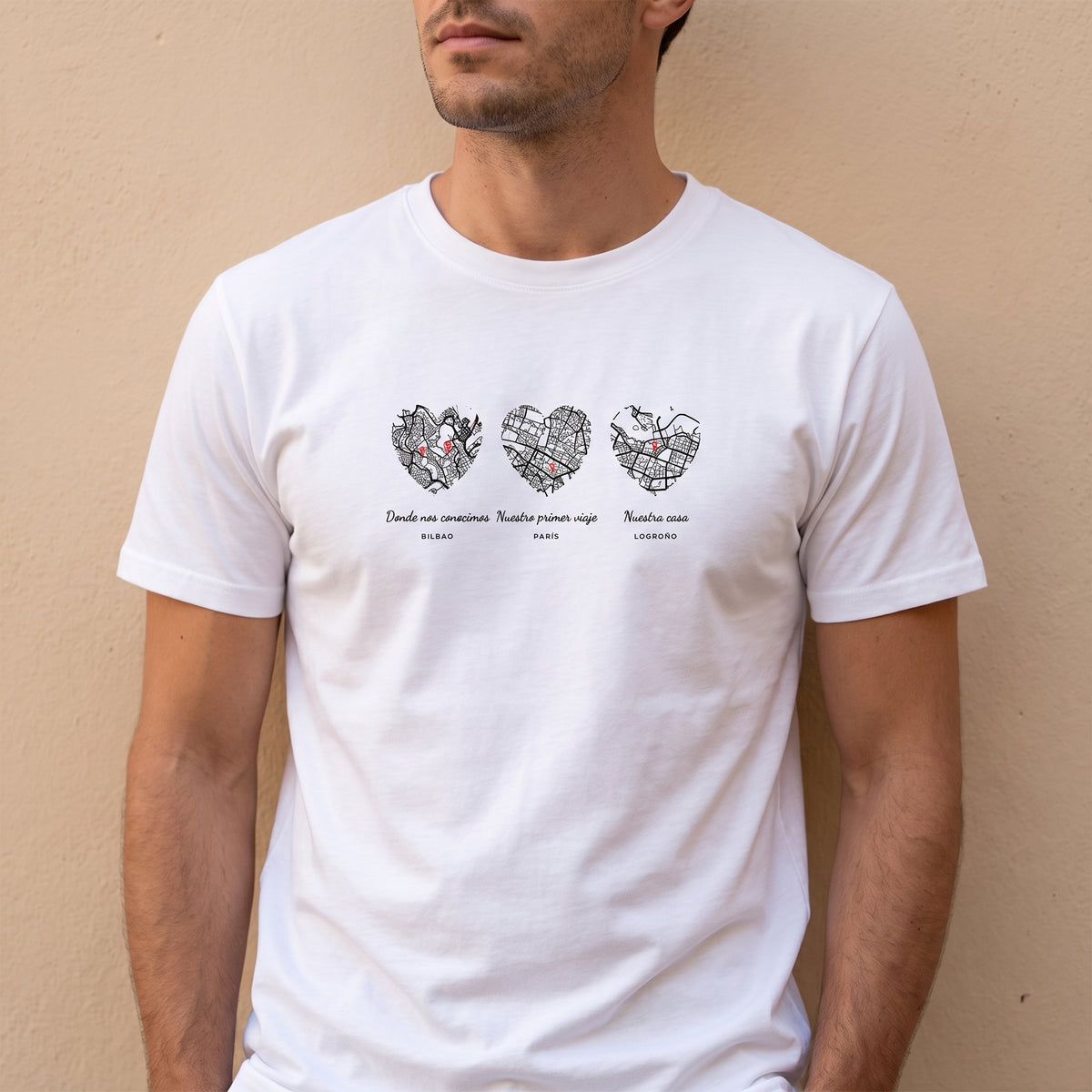 Hombre con la camiseta blanca personalizada con tres mapas en corazón: Bilbao, París y Logroño estampado en el pecho