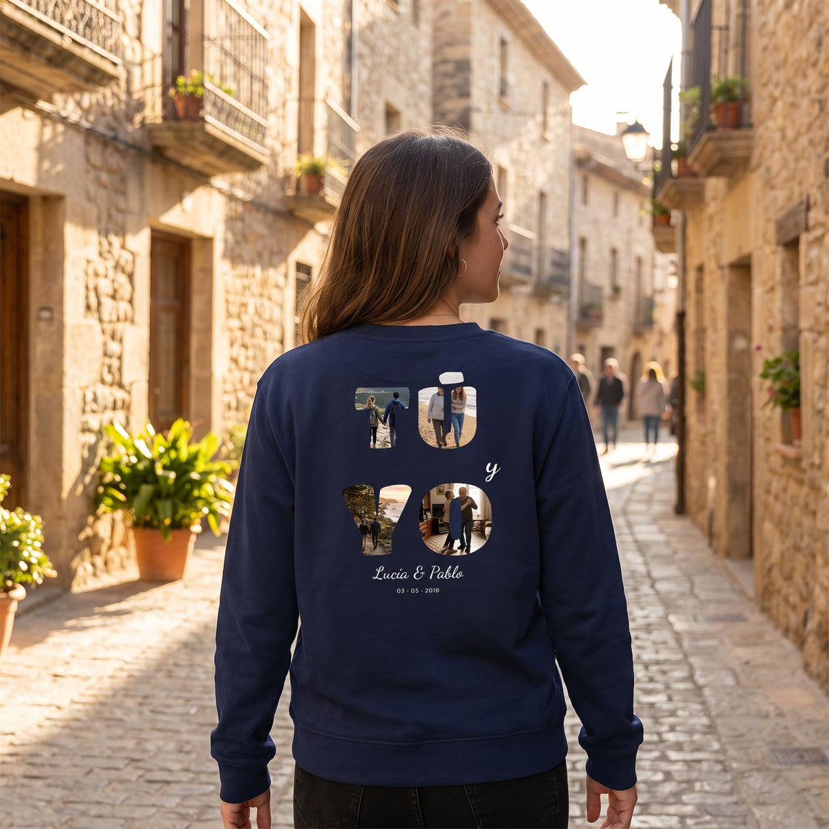 Mujer de espaldas con la sudadera azul marino personalizada con «TÚ y YO» con las letras rellenas de fotos y los nombres Lucía & Pablo estampado en la espalda