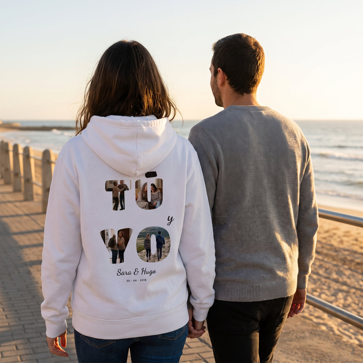 Paseo al atardecer con la sudadera con capucha blanca personalizada con «TÚ y YO» con las letras rellenas de fotos y los nombres Sara & Hugo estampado en la espalda